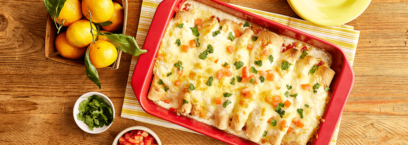 enchiladas served in a red tray on a wooden table