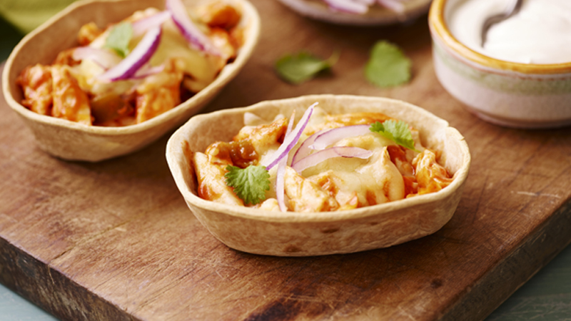 easy chicken enchiladas tacos filled with tender shredded chicken, gooey cheese served on a wooden board