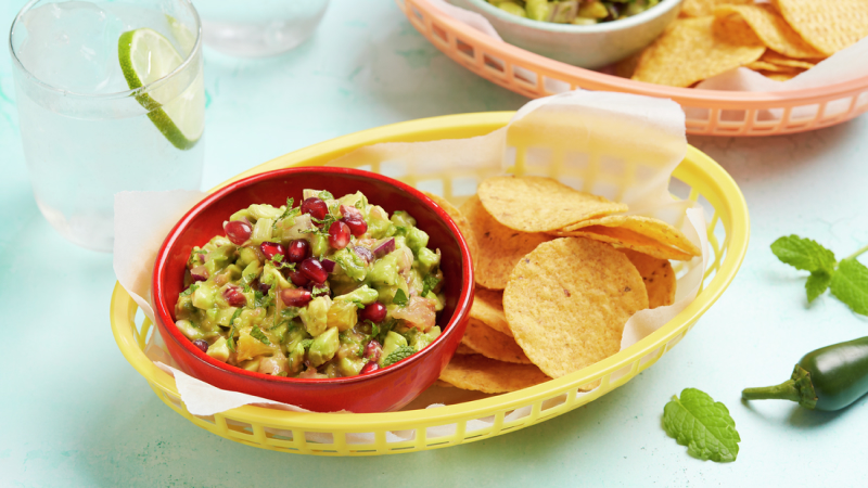 Fresh Citrus Guacamole served in bowl with nachips in a plate